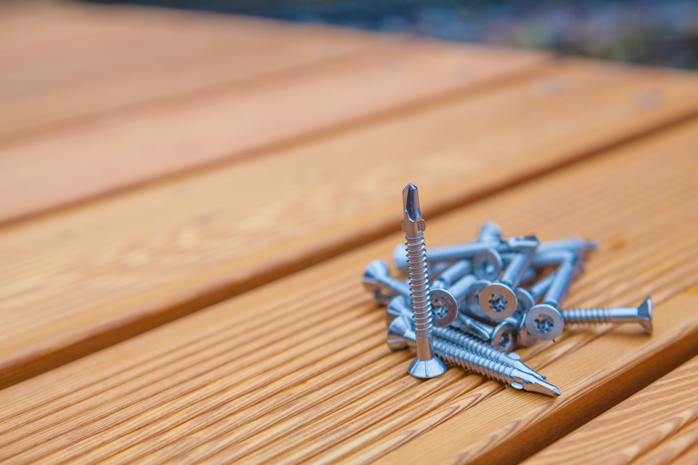 Self-drilling screws piled on a wooden deck, fastener