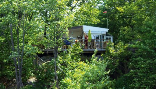 long view of the trottage from the water with Susana waving from the deck