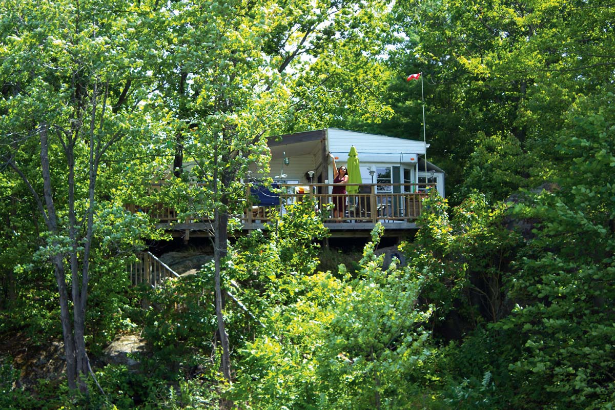 long view of the trottage from the water with Susana waving from the deck