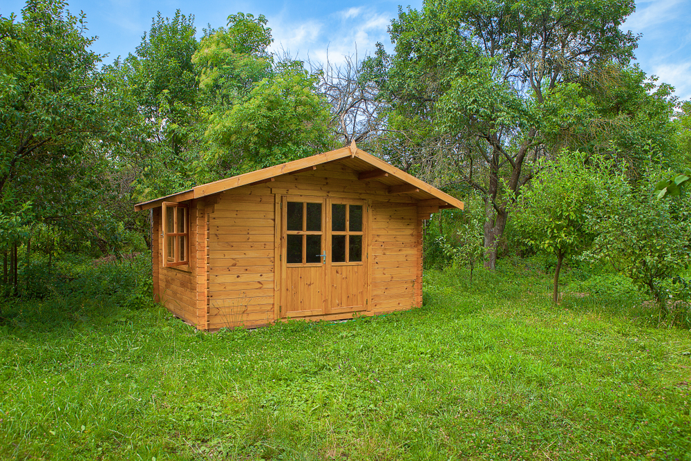 A small bunkie with trees in the background