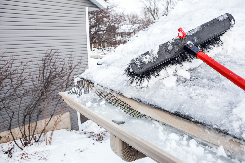 A snow rake clearing snow off a roof