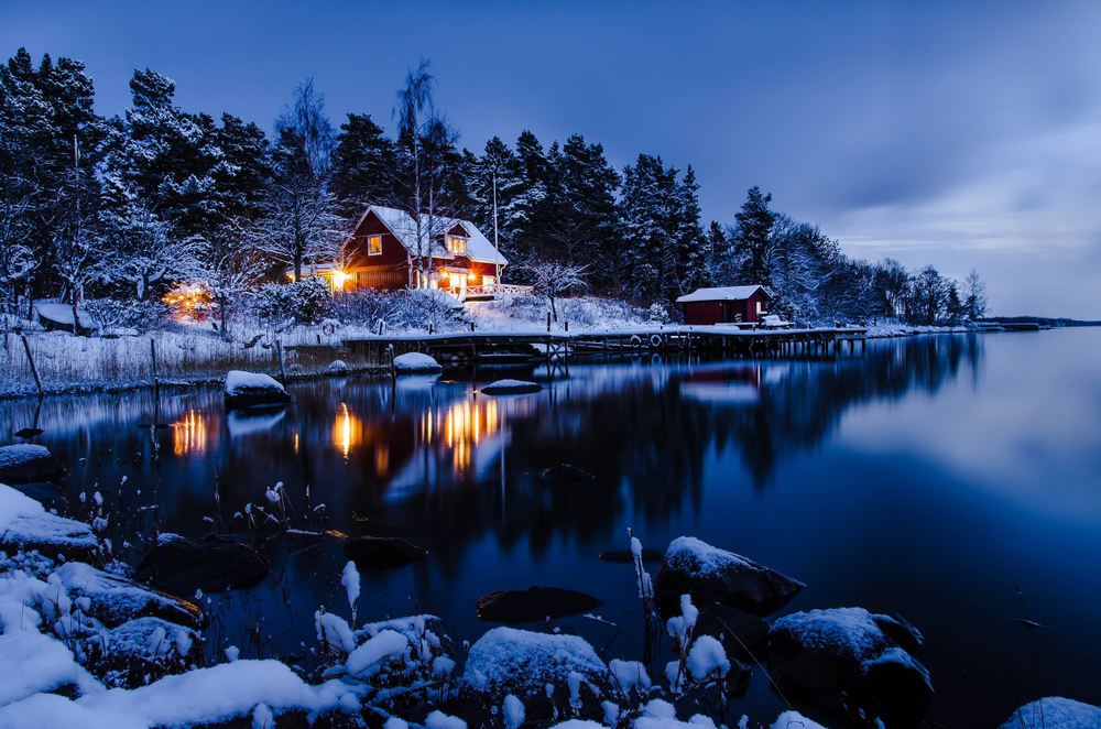An night shot of a cabin covered in snow