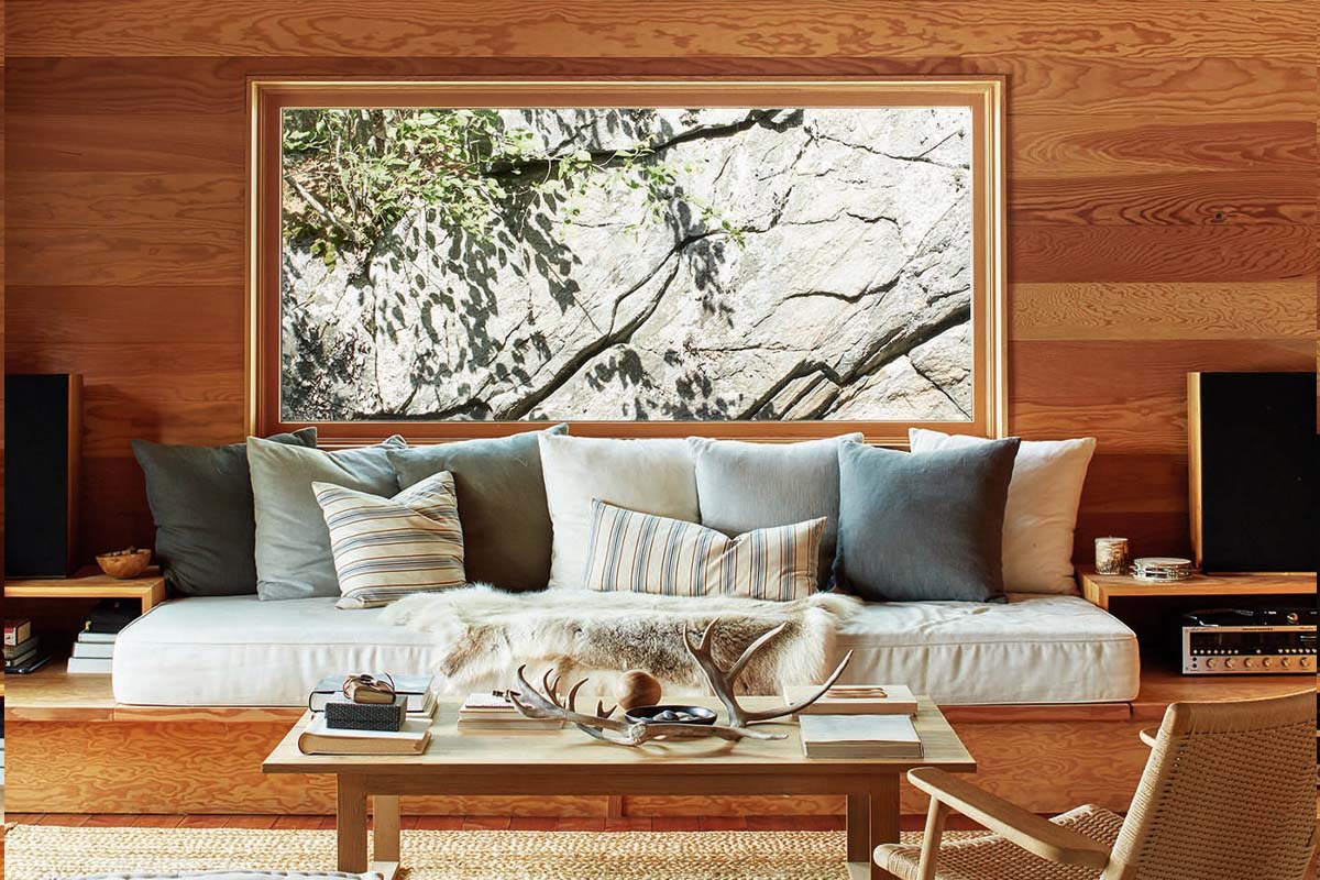 a cottage living room with a window that frames a granite rockface