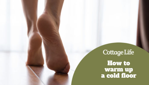 Female feet walking on warm heated floor close up view, barefoot girl legs going on hardwood living room wooden flooring at modern home house, domestic underfloor heating concept, close up rear view