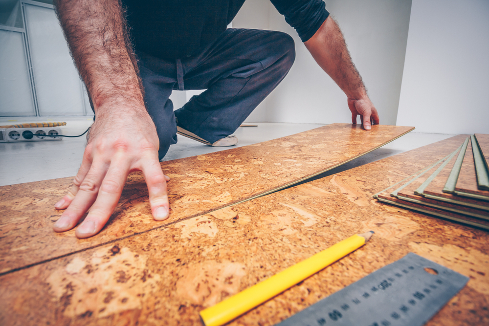 A man attaching panels of cork flooring