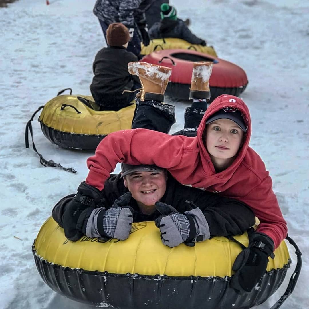 Kids laying on snow tube