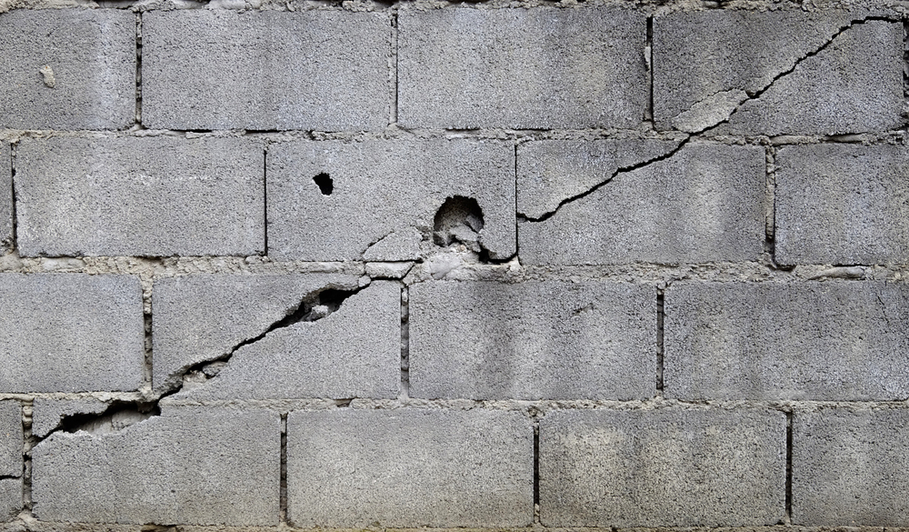 A cracked cinderblock wall