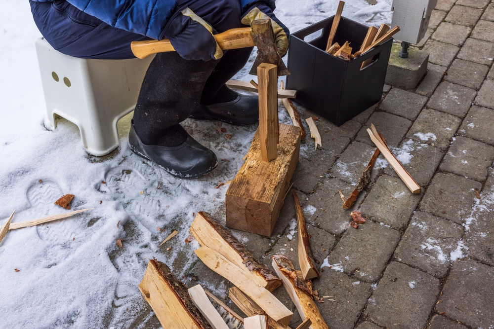 A close-up view of a man chopping wood for kindling