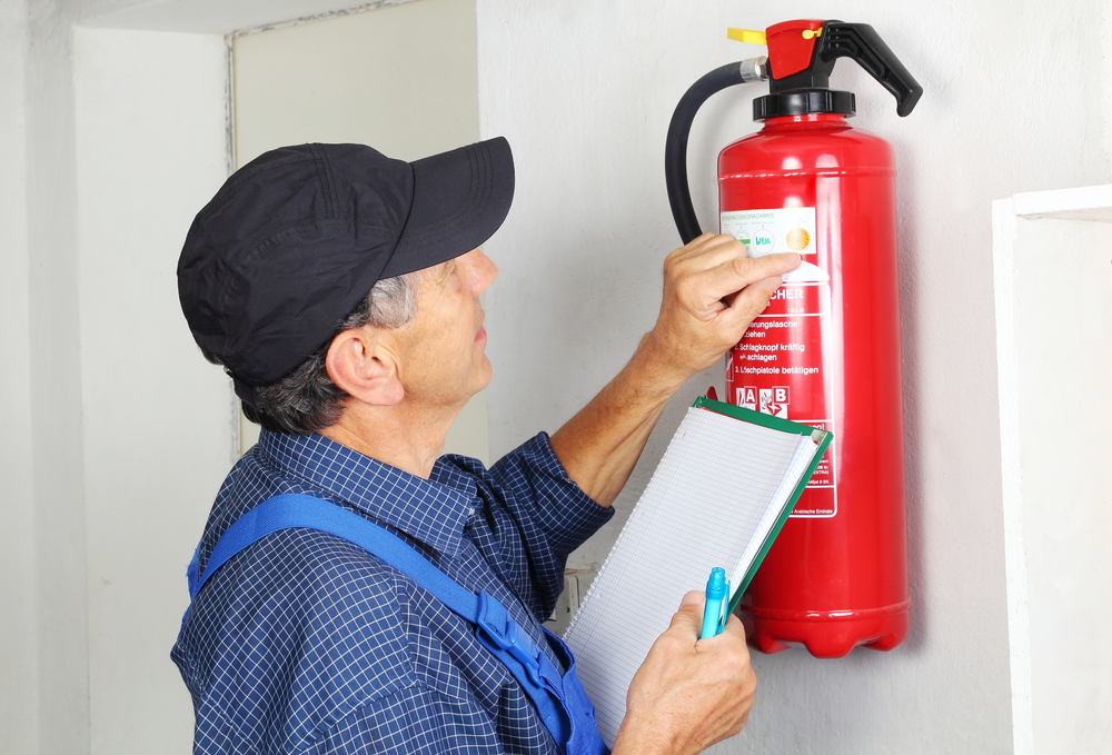 A man inspecting a fire extinguisher