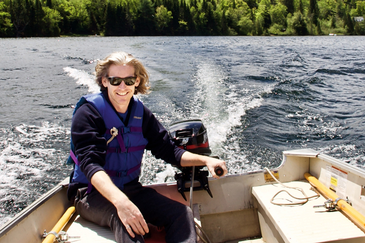 man in sunglasses drives a boat