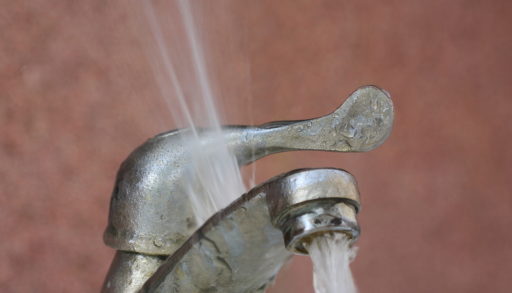 A faulty faucet spraying water into the air