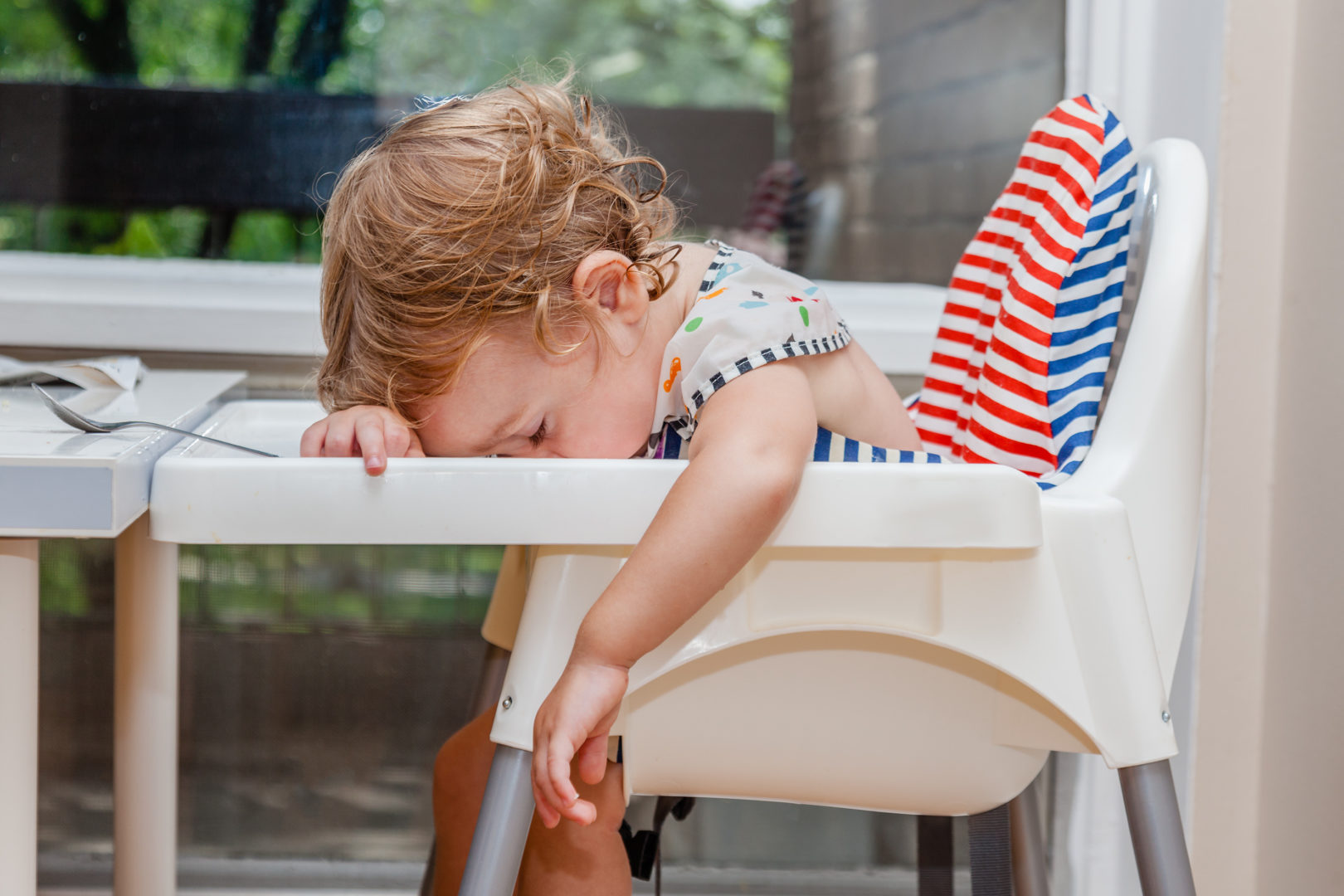 child asleep in high chair