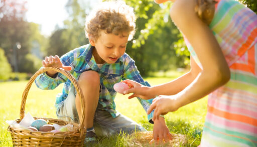 Boy and girl celebrating Easter, searching and collecting chocolate eggs.