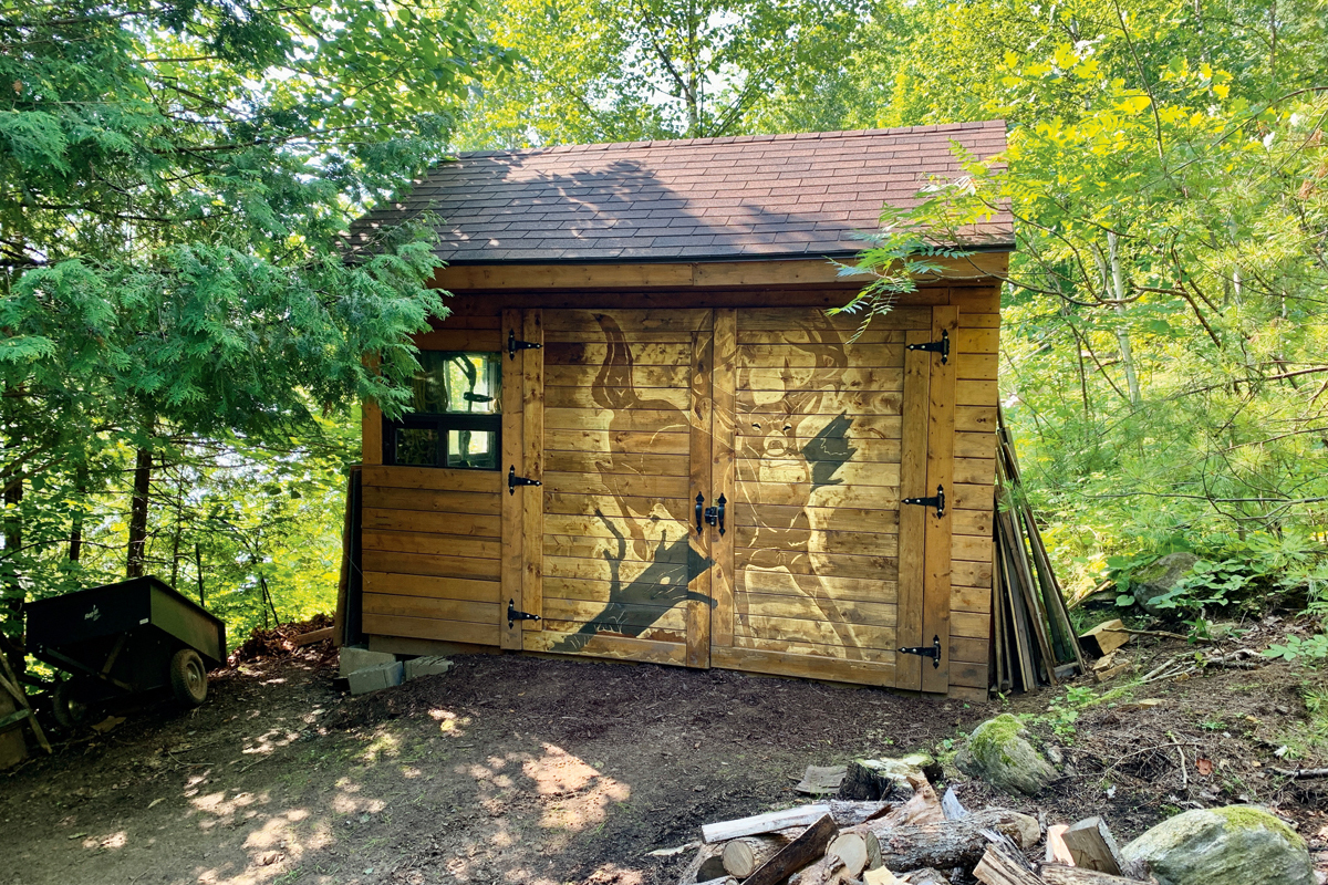 photo of an ATV shed with a deer carved onto the doors