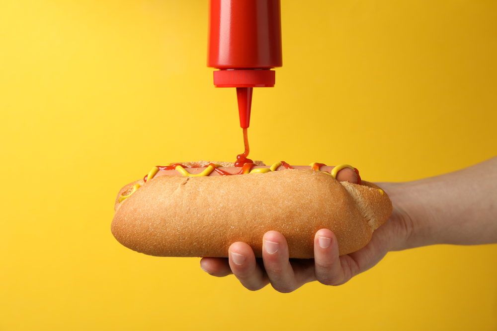 putting ketchup on a hot dog