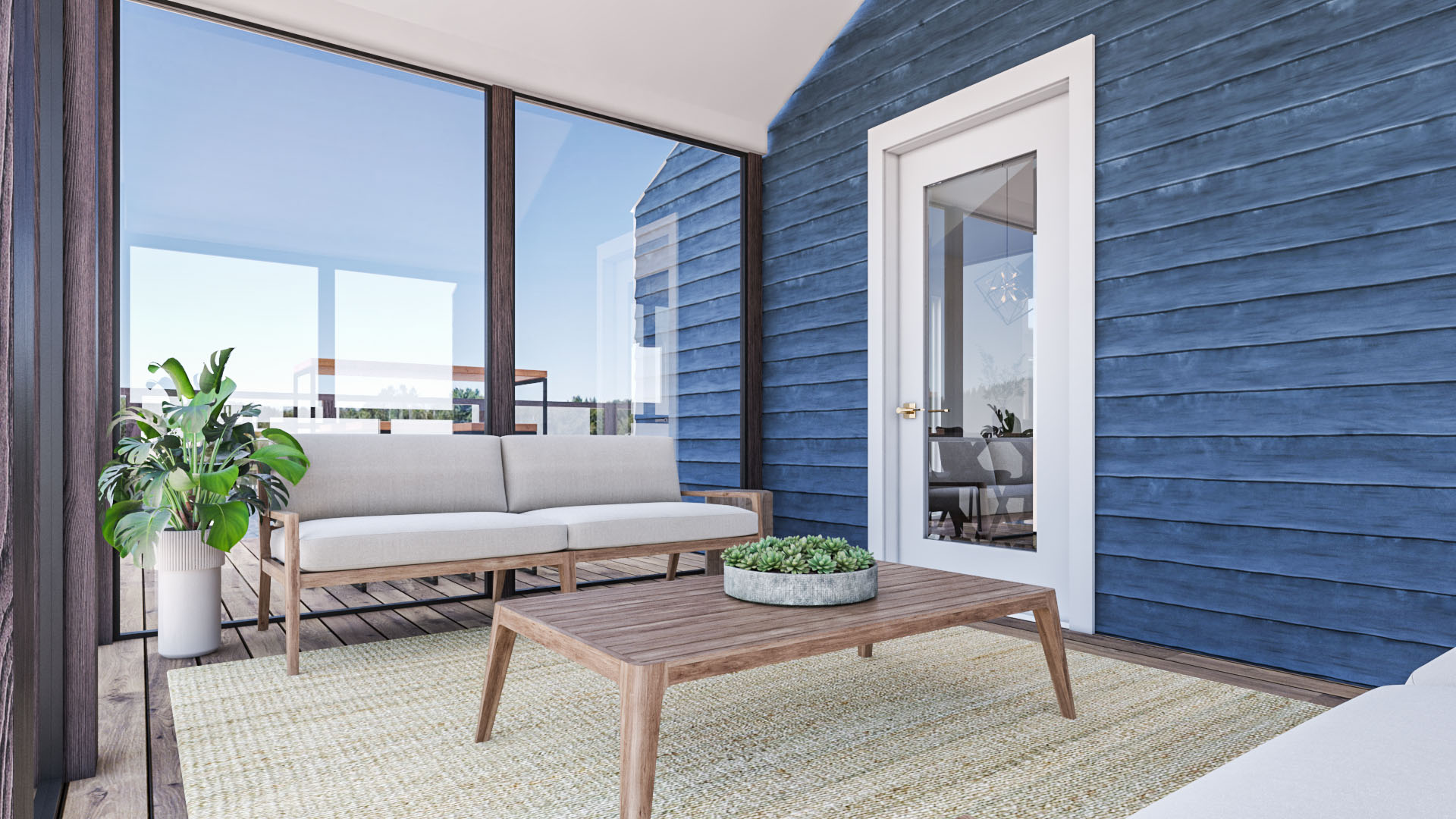A bright sunroom with a couch and table, large window panel walls, and a blue exterior wall of the cottage.