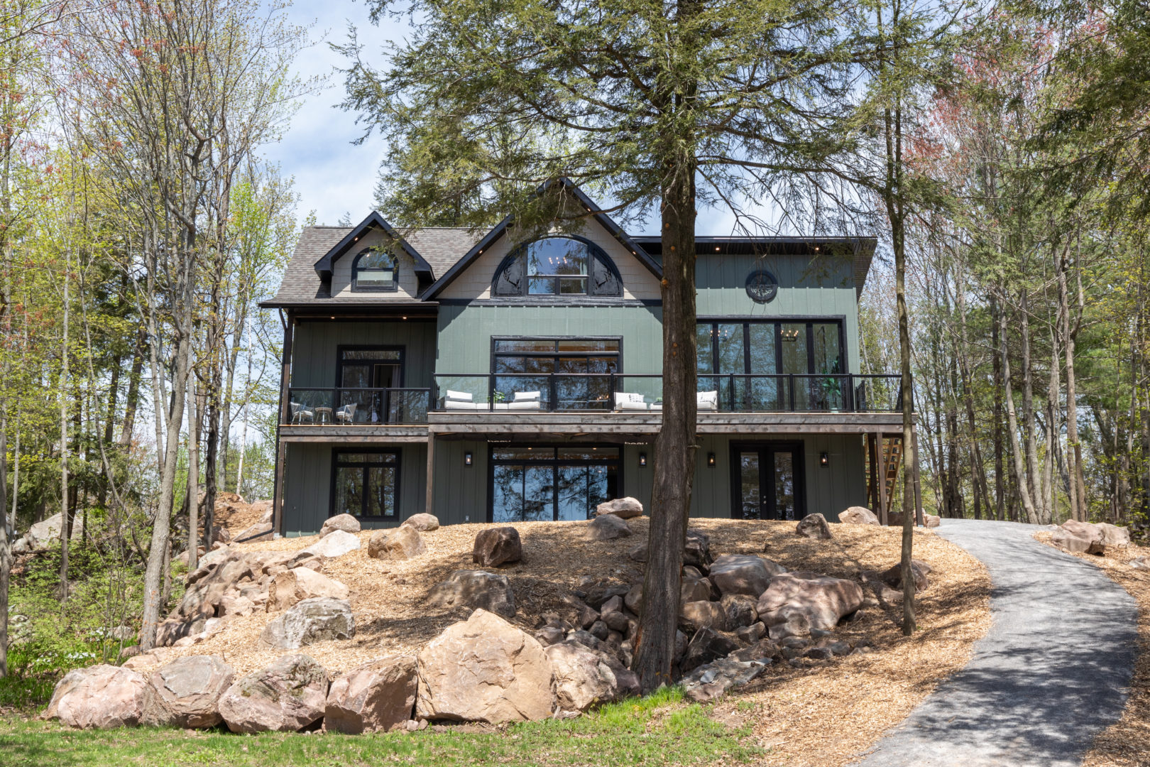 A large cottage with a green and brown exterior.