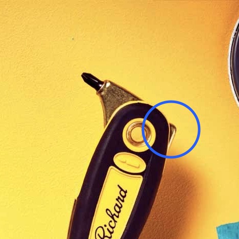 The end of a handle on a painter's combination tool with a metal cap on the edge.