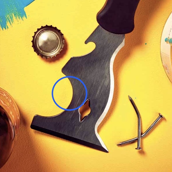 A painter's combination tool with the curved edge used for squeegeeing paint rollers circled.