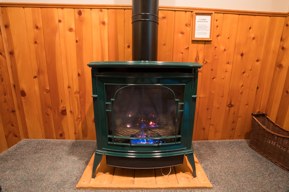A woodstove set on a concrete pad in a basement