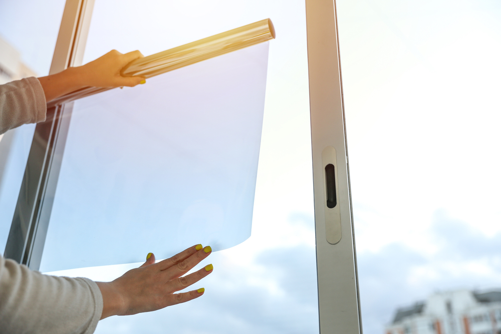Hands applying tint film to a window