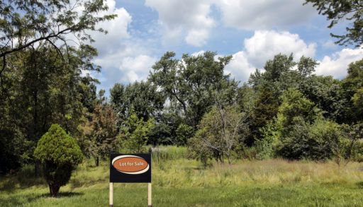 A vacant lot with a sign that says Lot for Sale