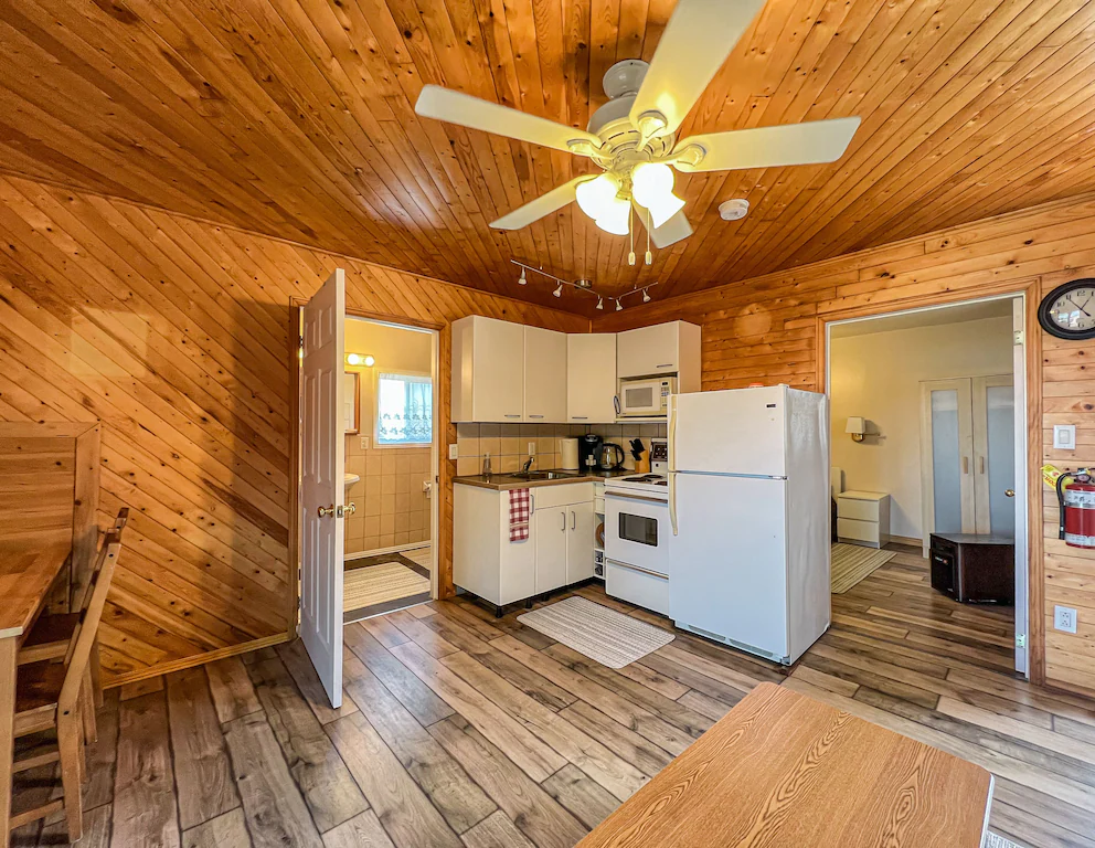 Large dining area and kitchen with wood floors.
