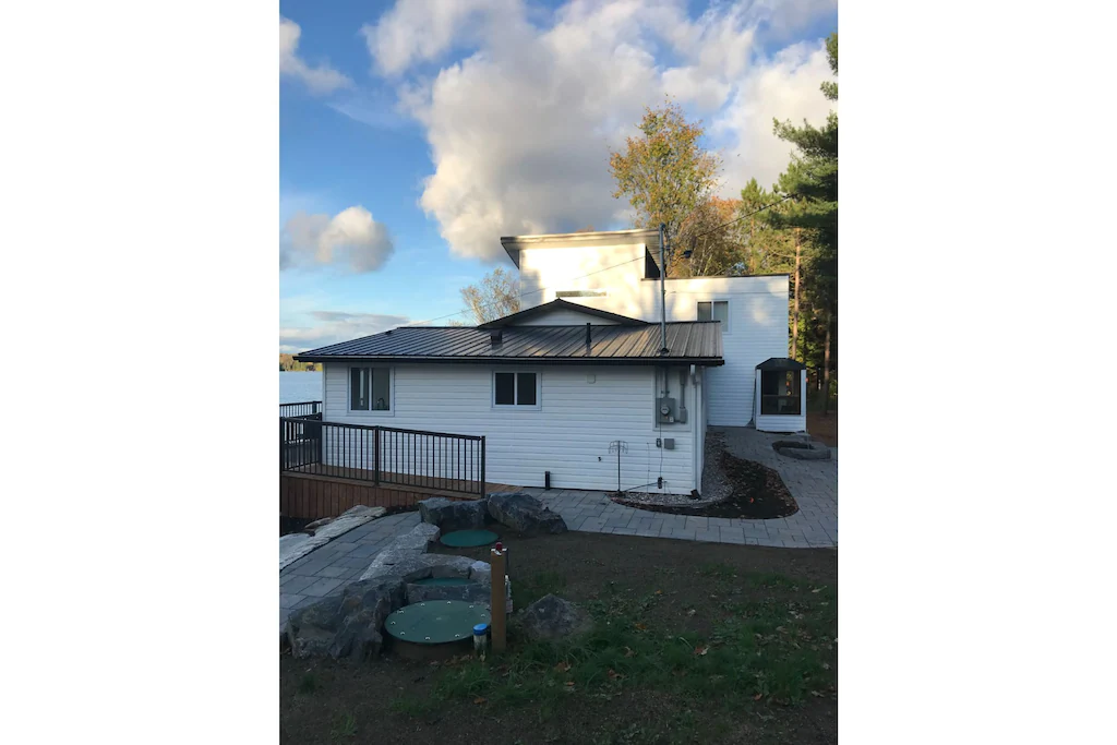 White cottage with stone path, leading to a ramp.