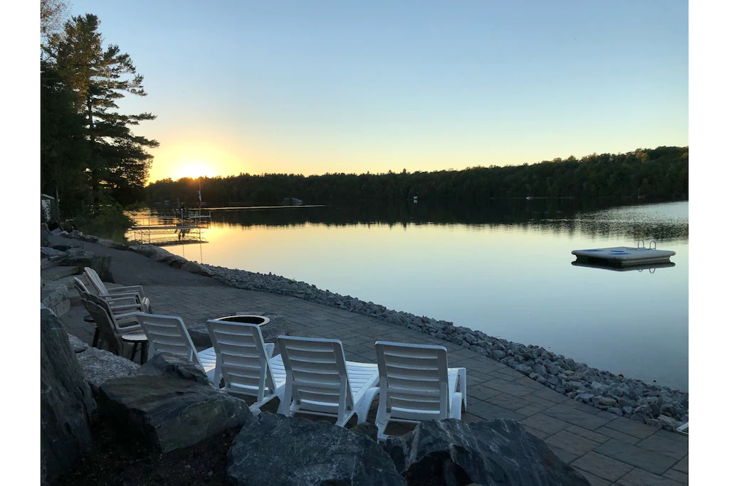 Sunset dock with chairs along the waterfront.