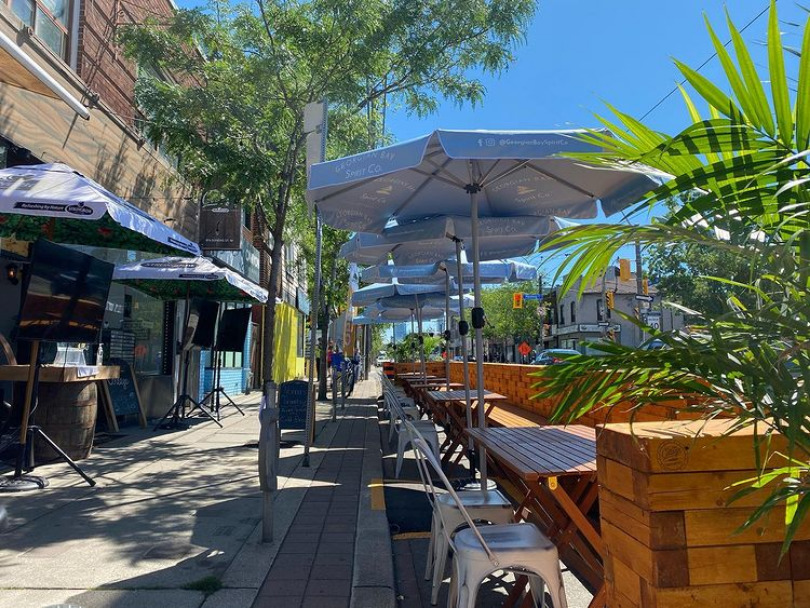 The Cottage Restaurant and Bar patio equipped with picnic tables and umbrellas.
