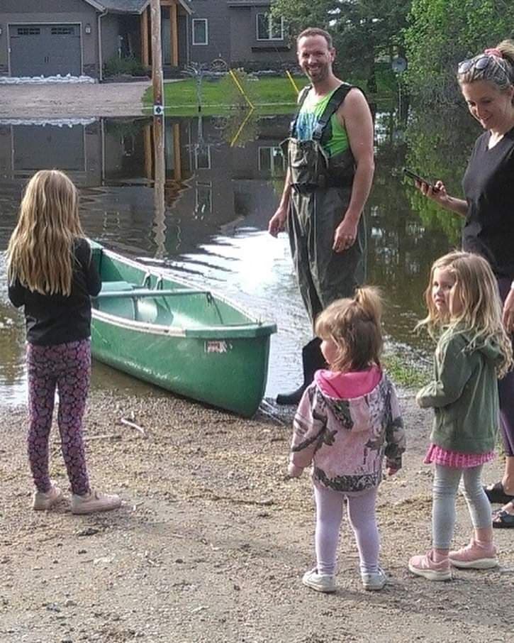 The Thompson family near their canoe by the Manitoba flood waters