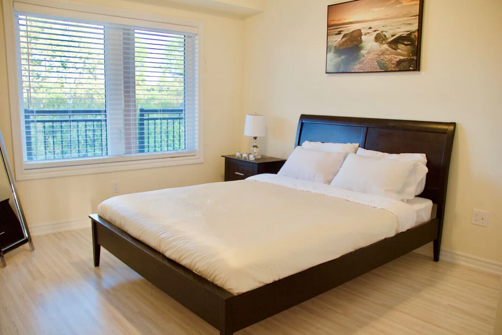 Bedroom with queen-sized bed and large window.