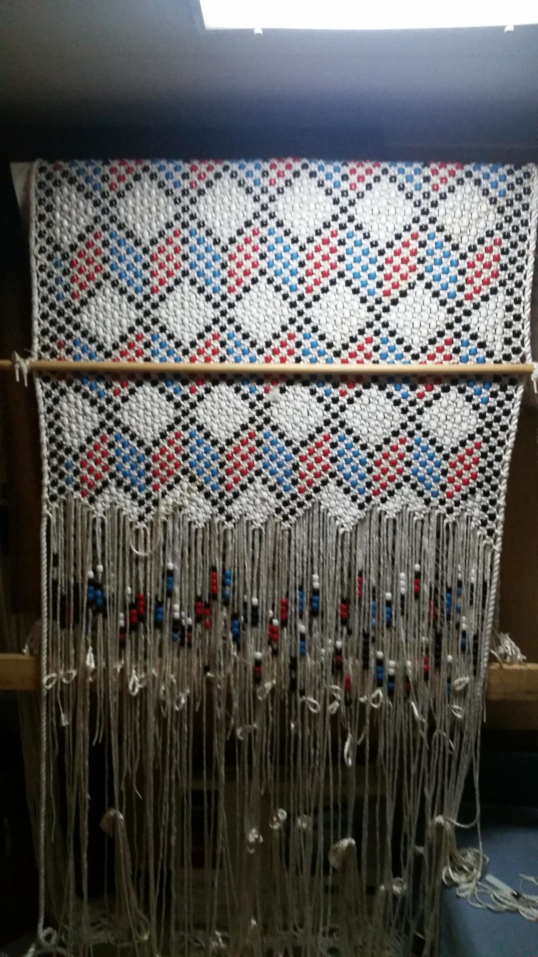 Using a homemade loom, made out of lumber, to construct the hammock.