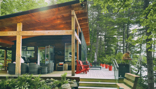 the exterior of the Kelars newly built cottage with a wrapround porch and the sun shining