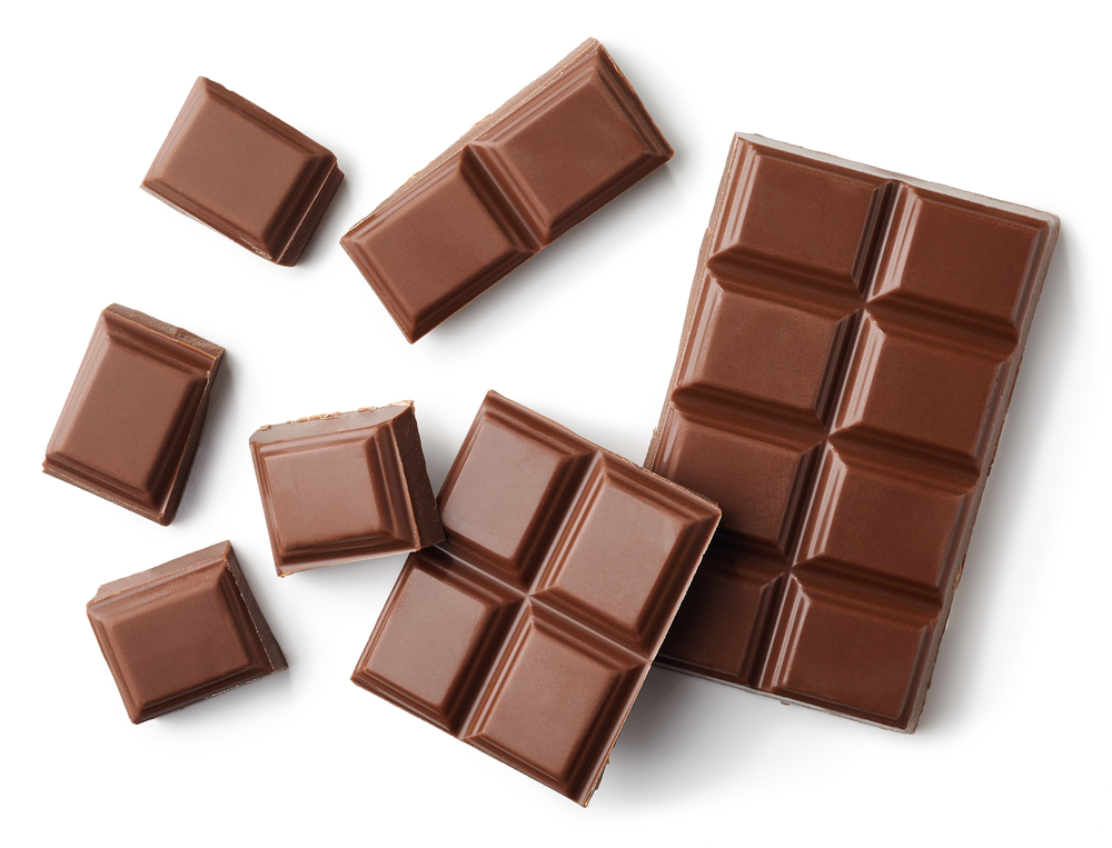 Milk chocolate bar pieces against a white background
