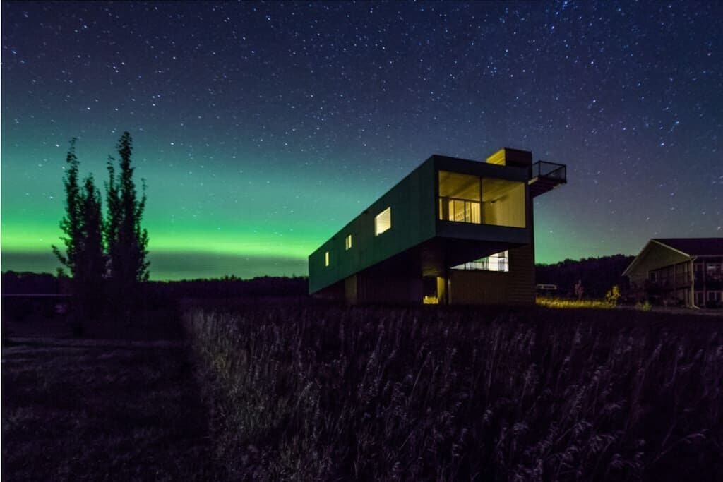 Northern lights light up the sky and container cabin
