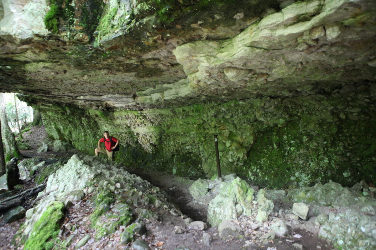 a man stands in the natural caves at Charleston Lake Provincial Park