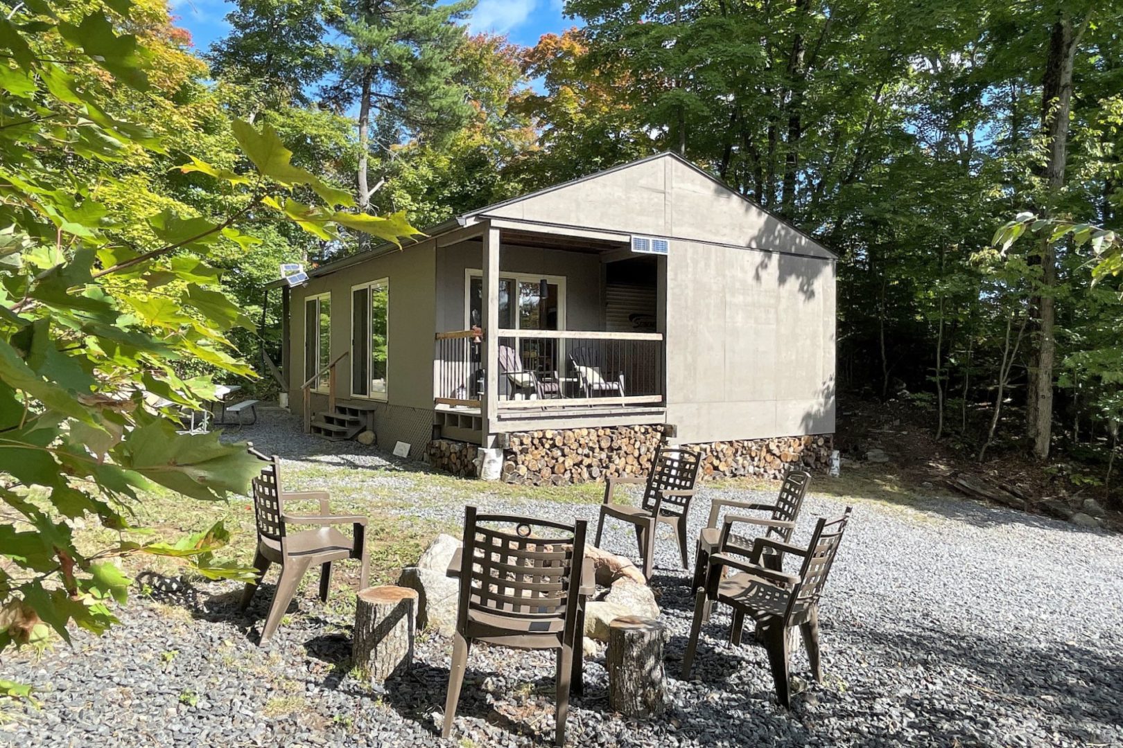 guest trailer with attached porch and fire pit outside