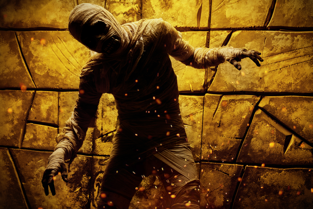 An illustration of a mummy climbing out of a tomb