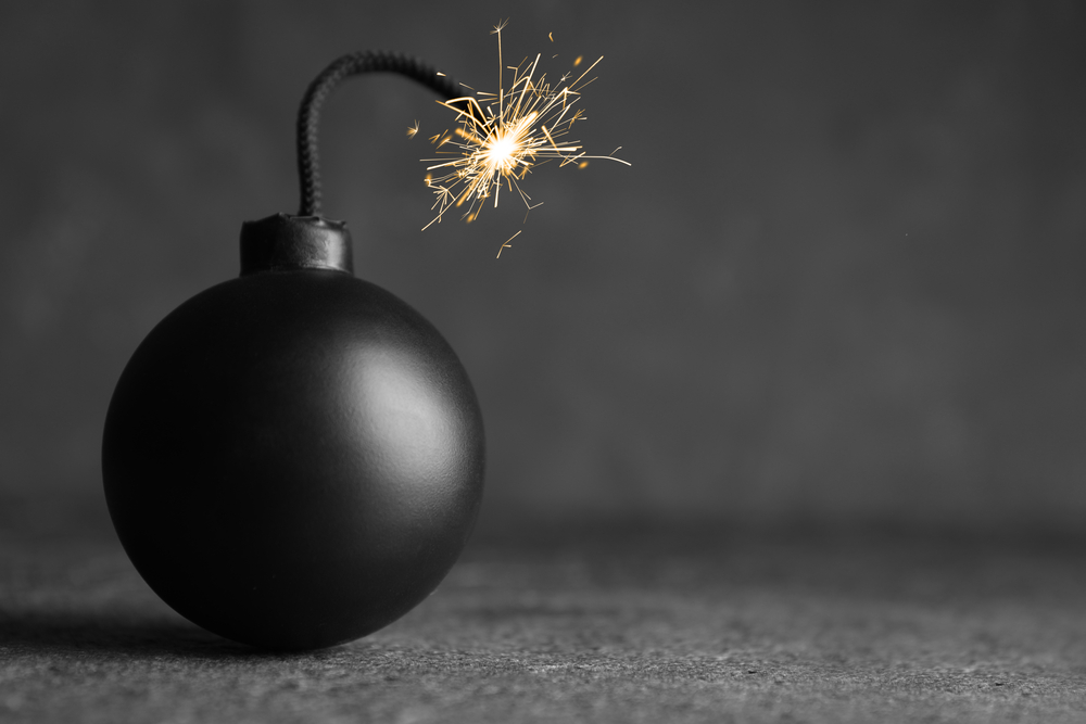 An old-fashioned bomb against a grey background