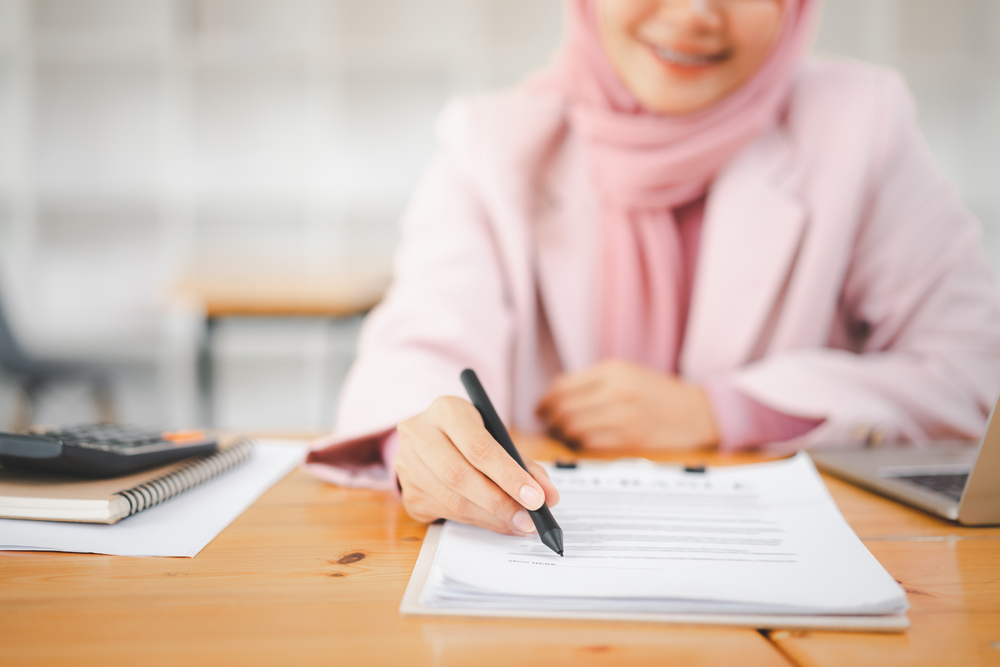 muslim business woman with contract agreement document. halal mortgages