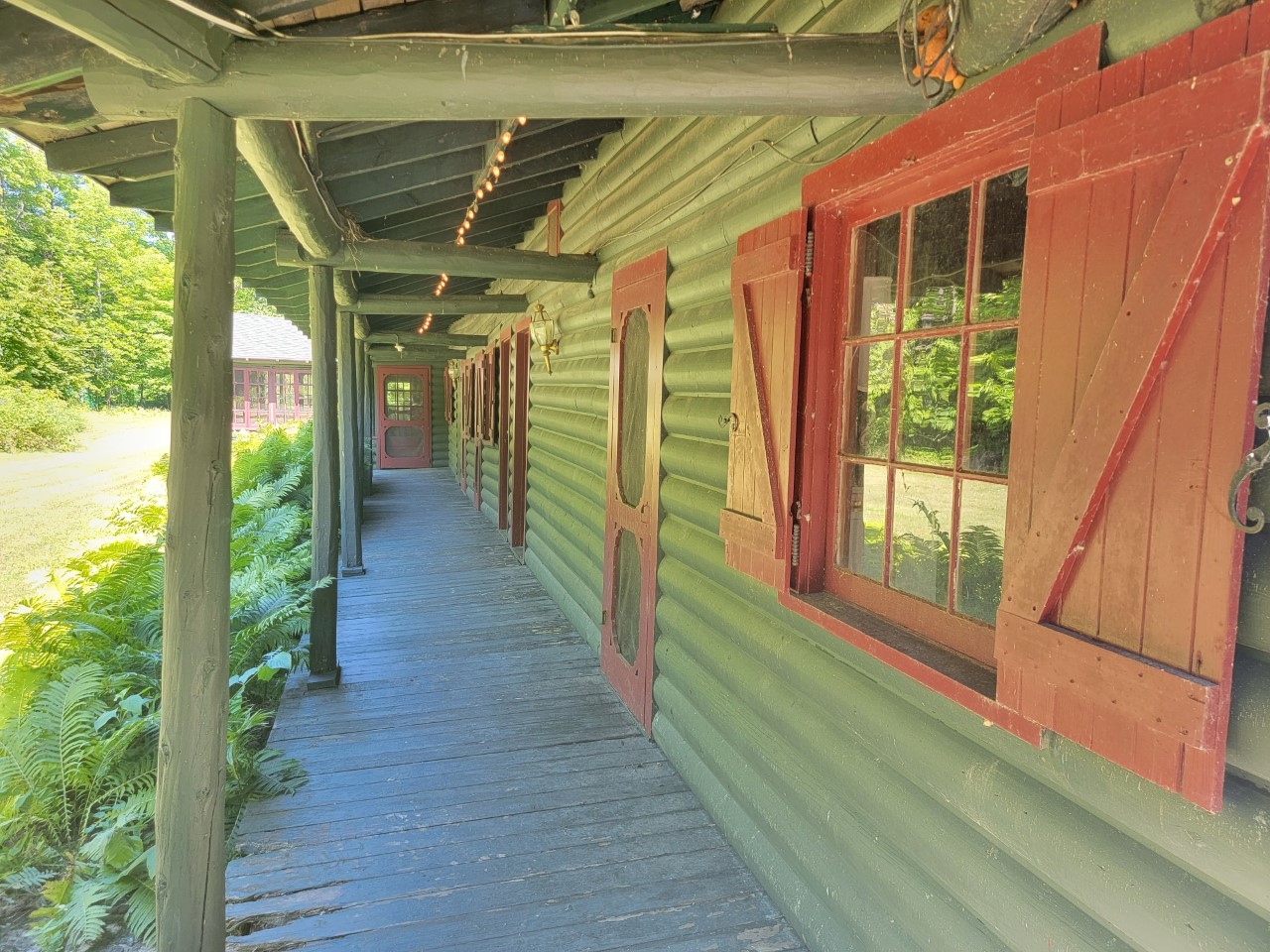 Long covered veranda against a log cottage.