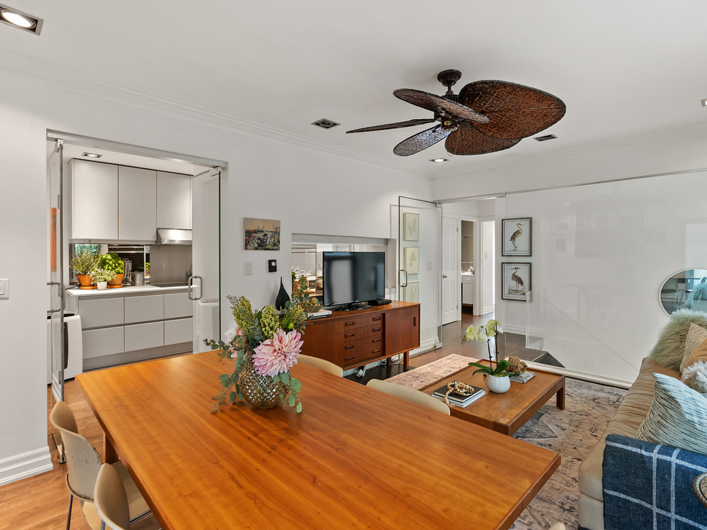 A small living space with a dining table, a couch and a televsion.