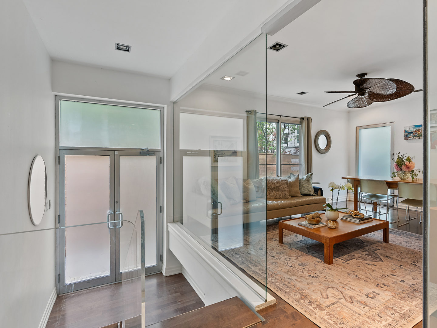 An entryway with frosted glass doors, that leads into a small living area.