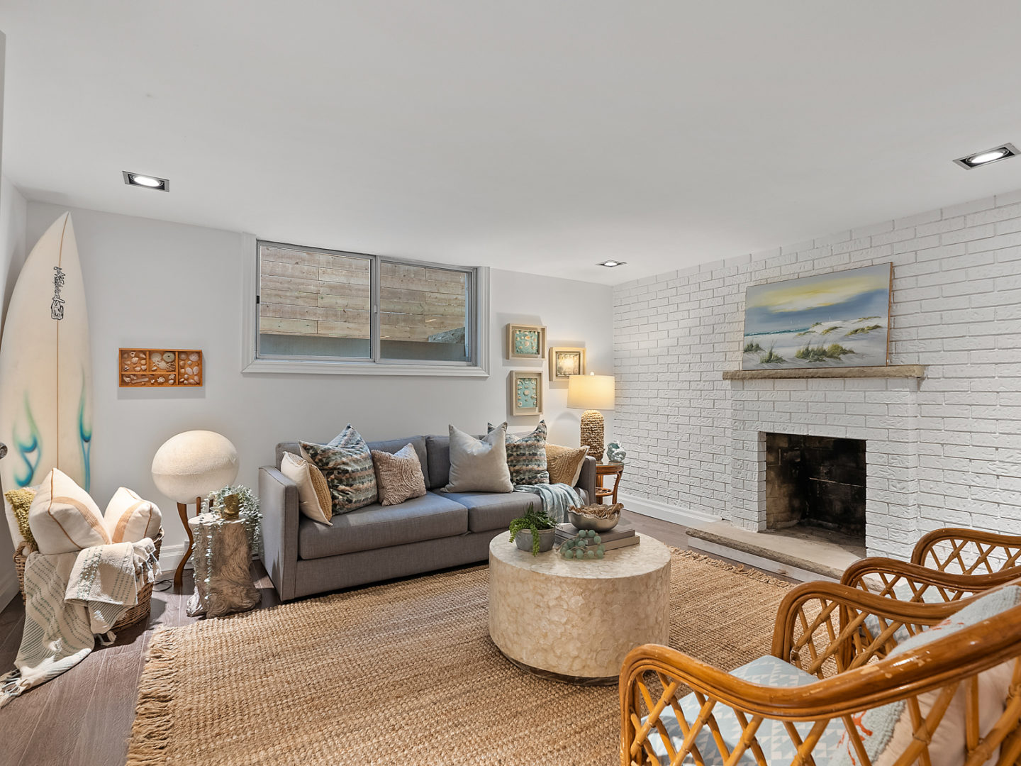 A modest living space with hardwood floors, a couch, a fireplace, and a chair.