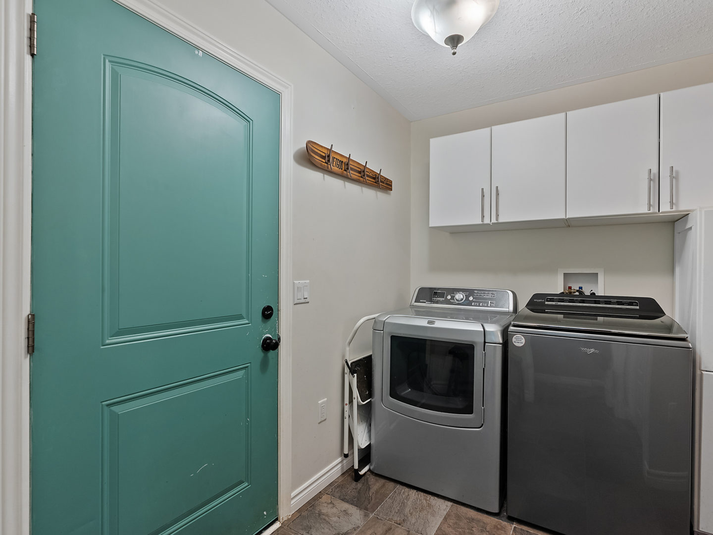 A small area with a washing machine and dryer, and a door off to the side.