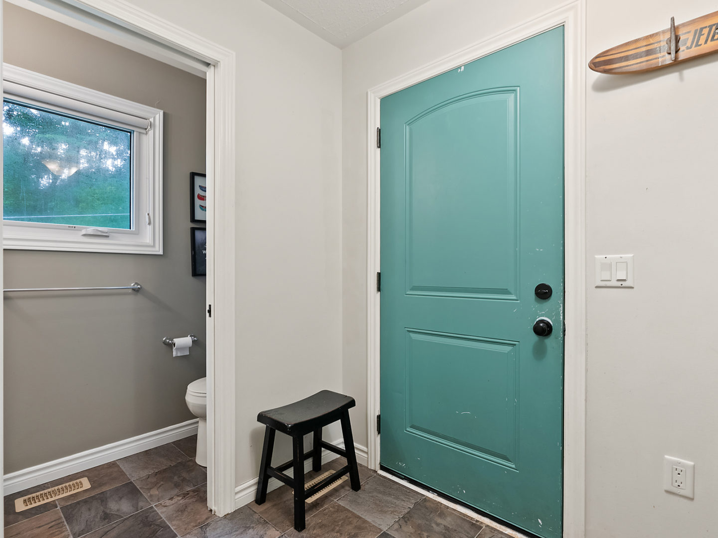A small entrance area in a house with a powder room off the side of the entrance.