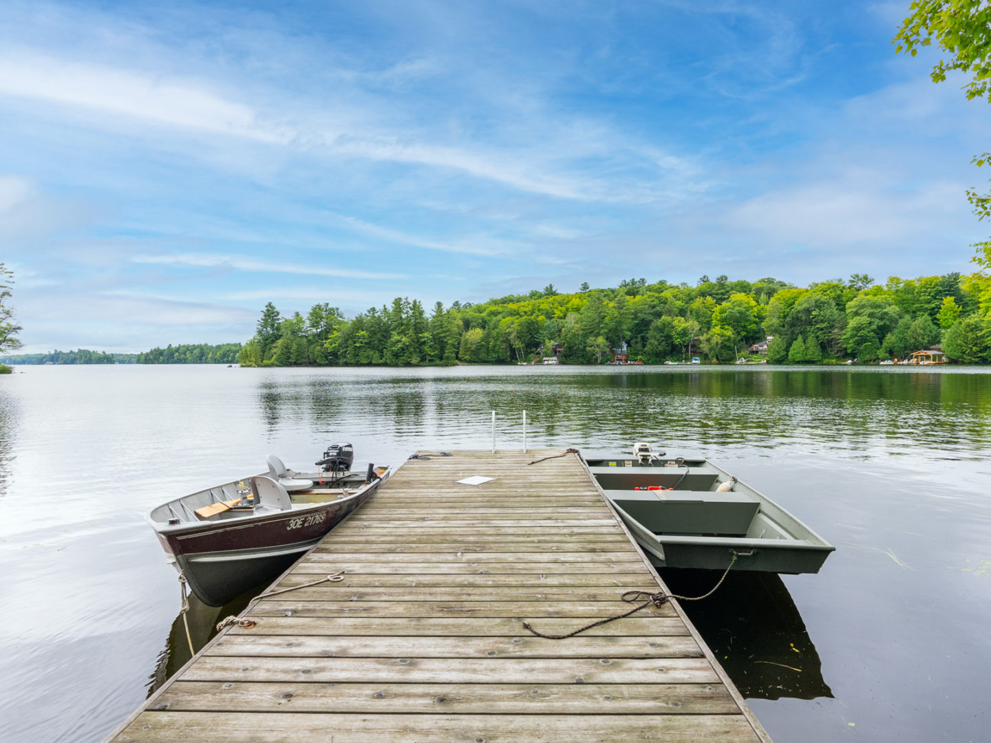 A long dock looking out over a quiet lake.