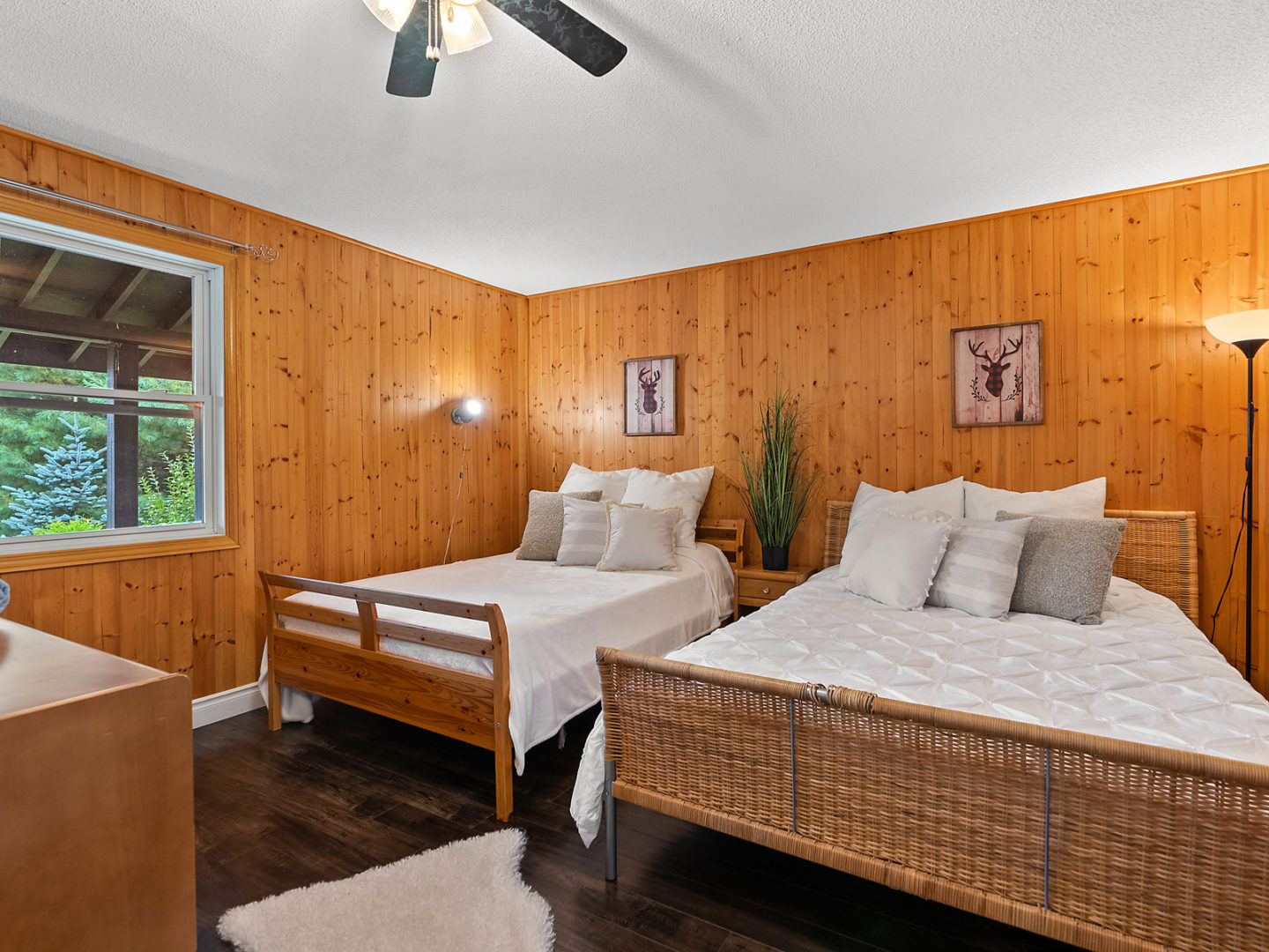A big bedroom with two large beds and wood-panelled walls.