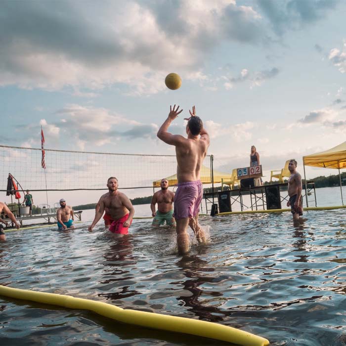 A group of men playing volleyball in the lake